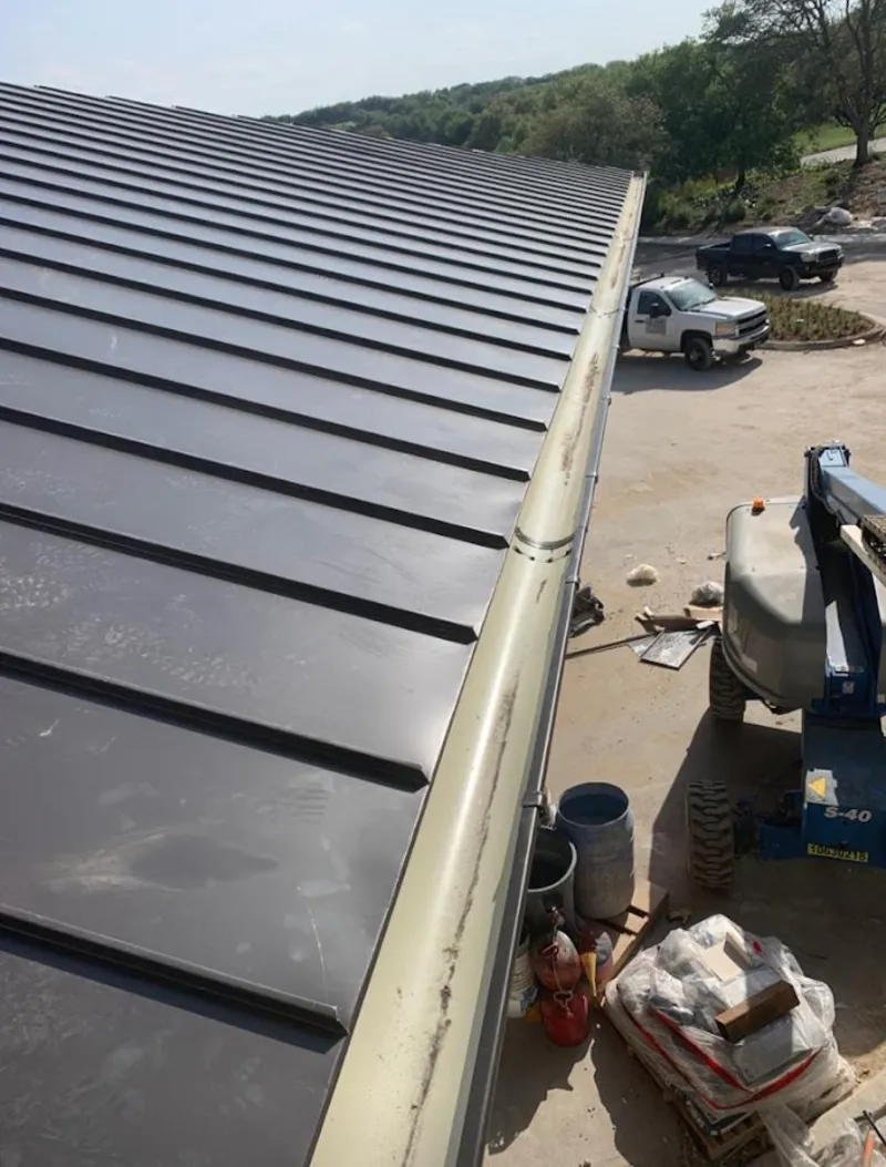 Standing seam panel and gutter detail on a metal roofing jobsite in Madison